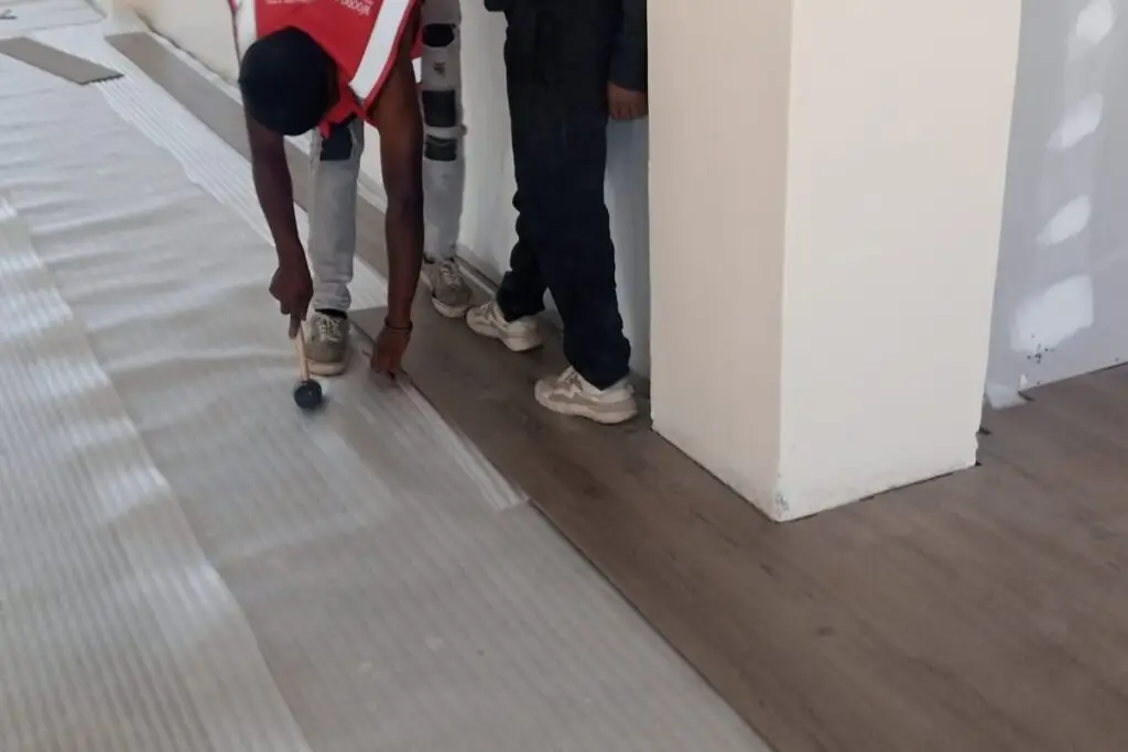 Workers installing durable SPC (Stone Plastic Composite) flooring in a room