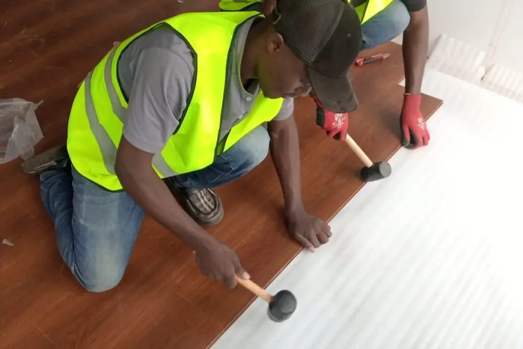 Strofix Construction and Interior Design Kenya Team laying SPC flooring panels in a room for a sleek and durable finish